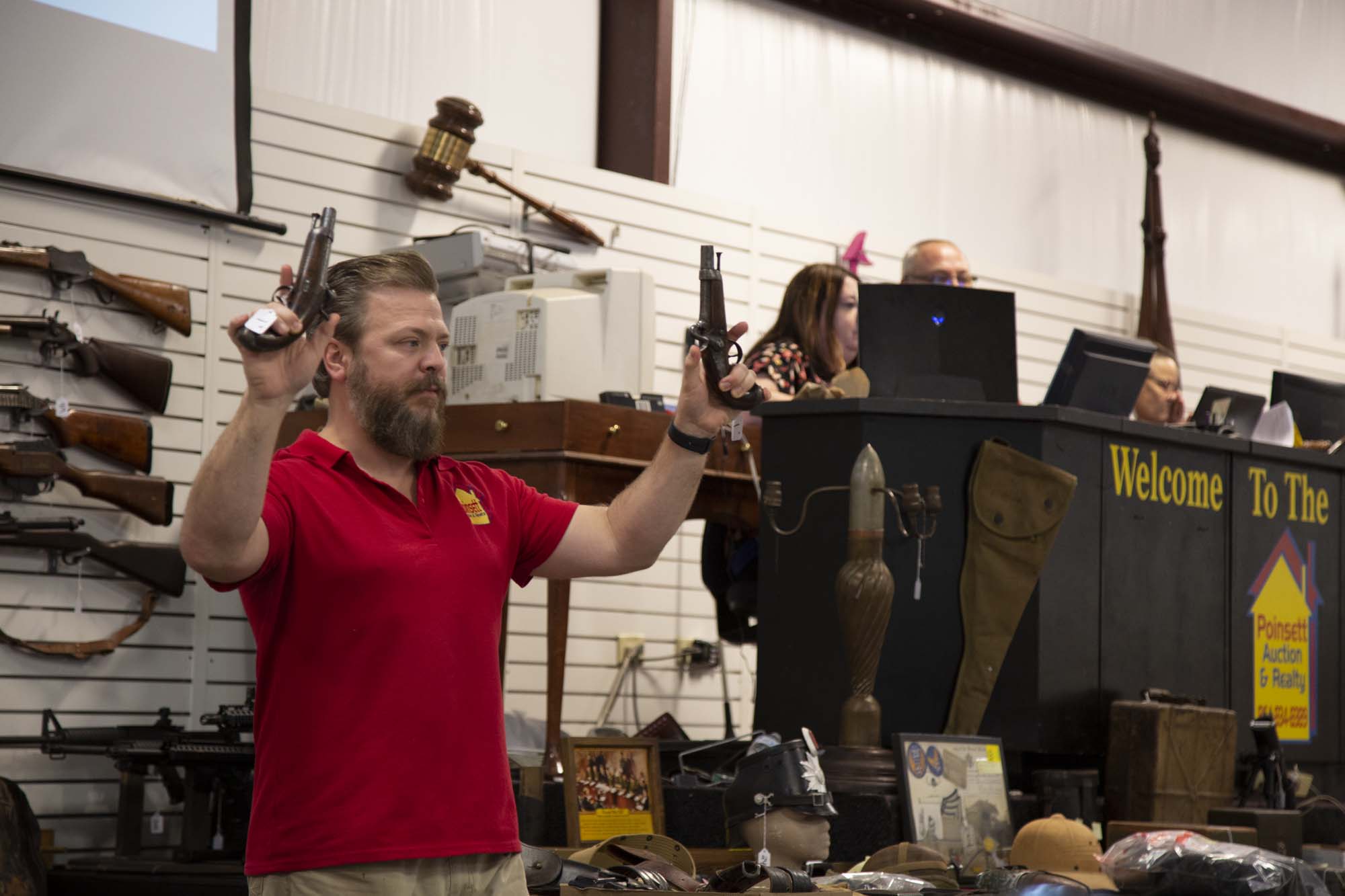 Auctioneer holding two pistols